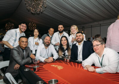 Diverse group of professionals celebrating at Camp One Step fundraising event indoors.