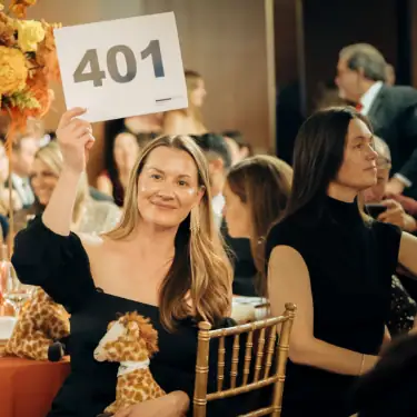 Auction bidding at Camp One Step charity event for pediatric cancer awareness and support.