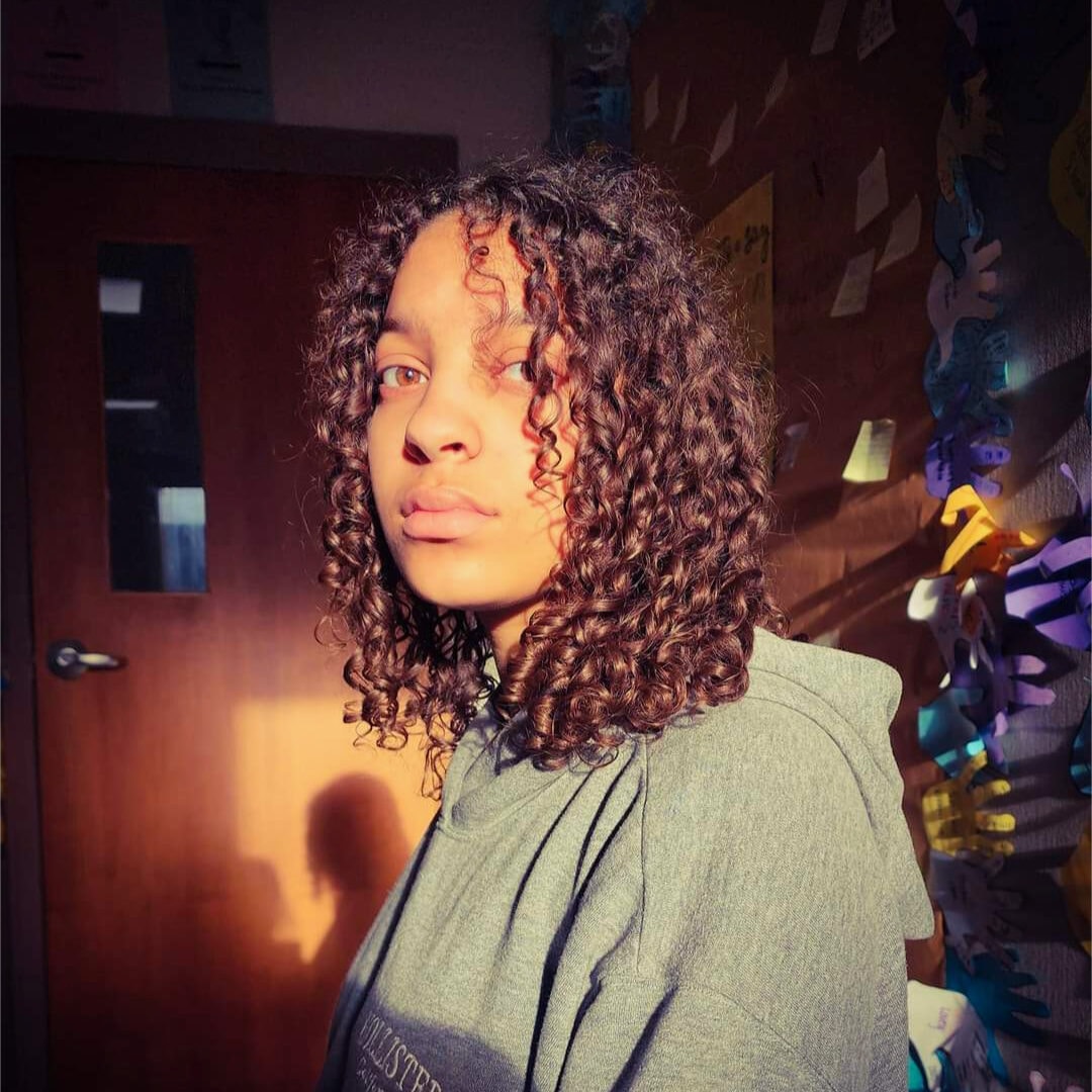 Natural curly hair portrait at Camp One Step in warm sunlight.