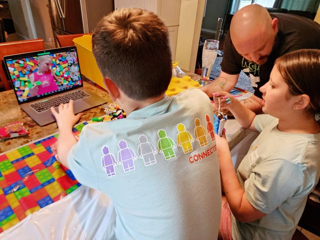 A family playing with Lego blocks together at Camp One Step, fostering creativity and family bonding in a warm setting.