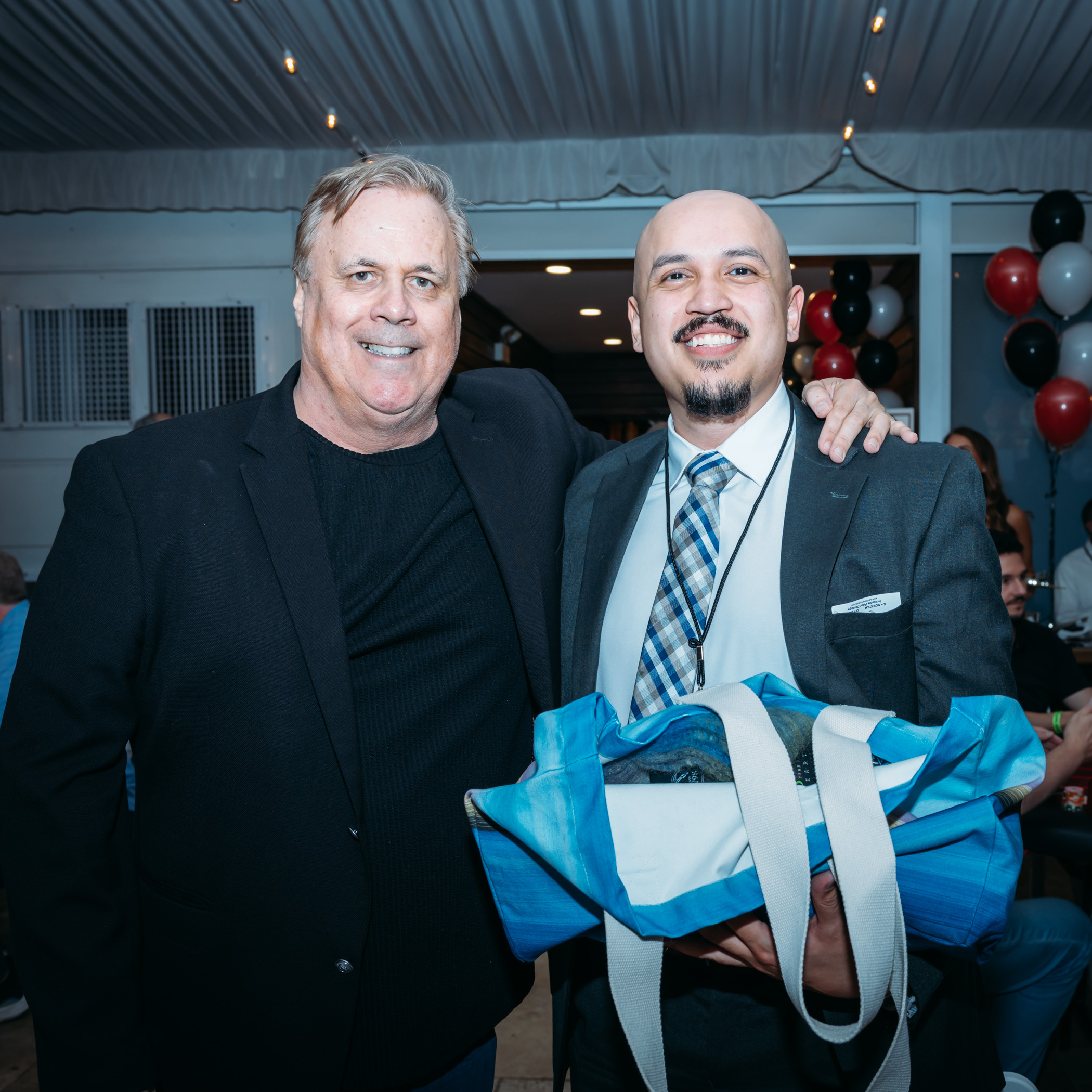 Two men smiling at an event