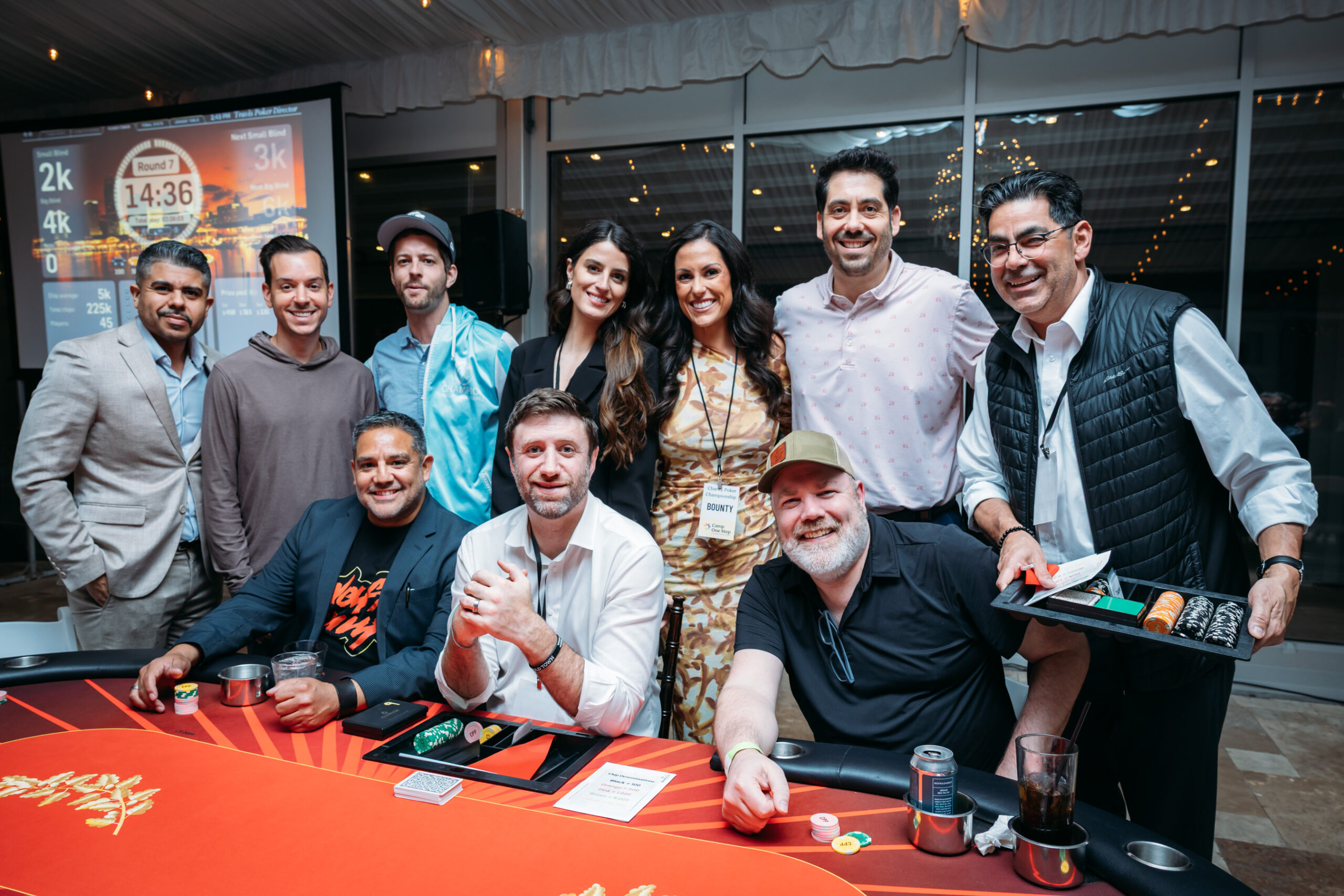 Group at poker event with table and screen.