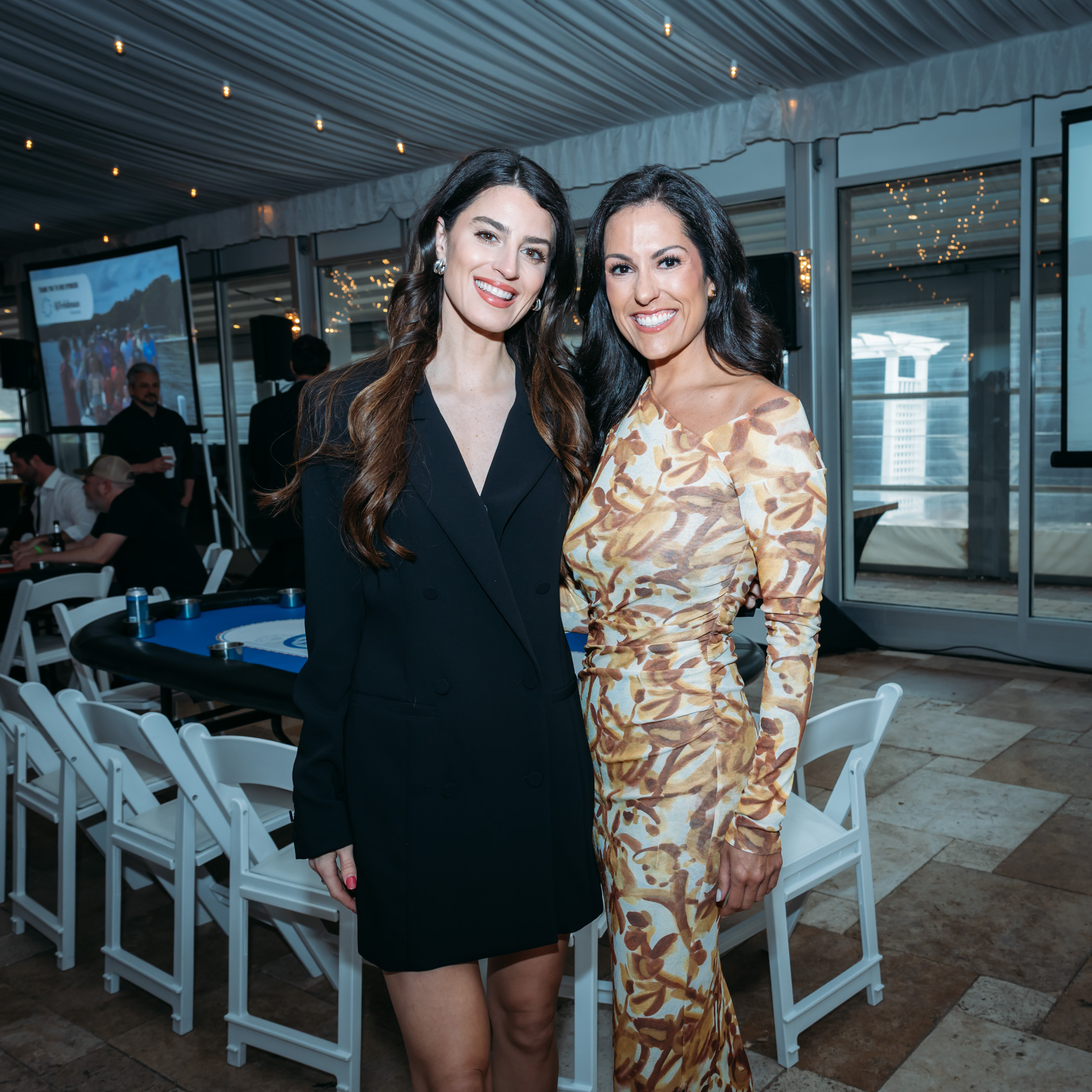 Two women posing at an indoor event
