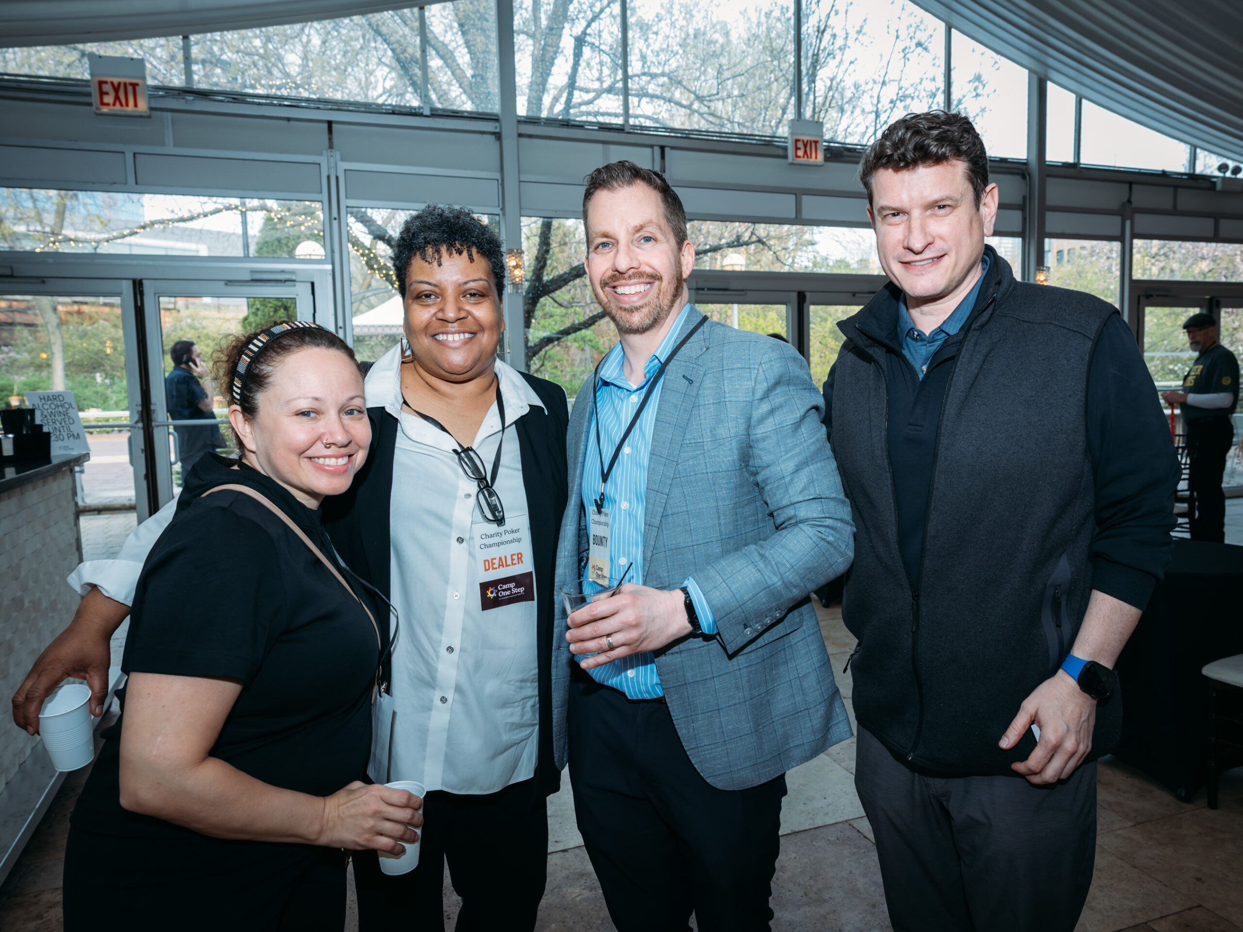 Group of four smiling people indoors