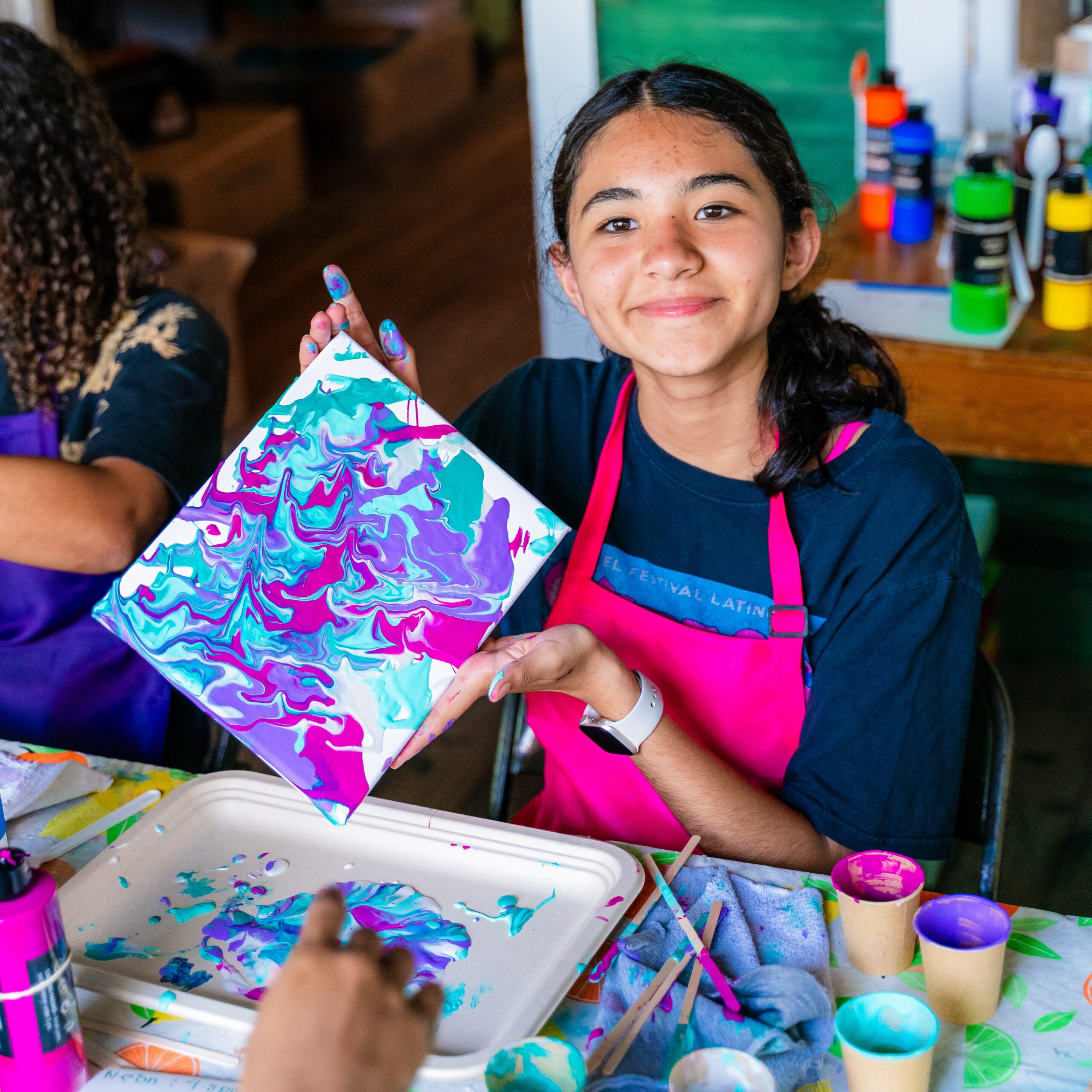 Young artist displaying a colorful abstract painting.