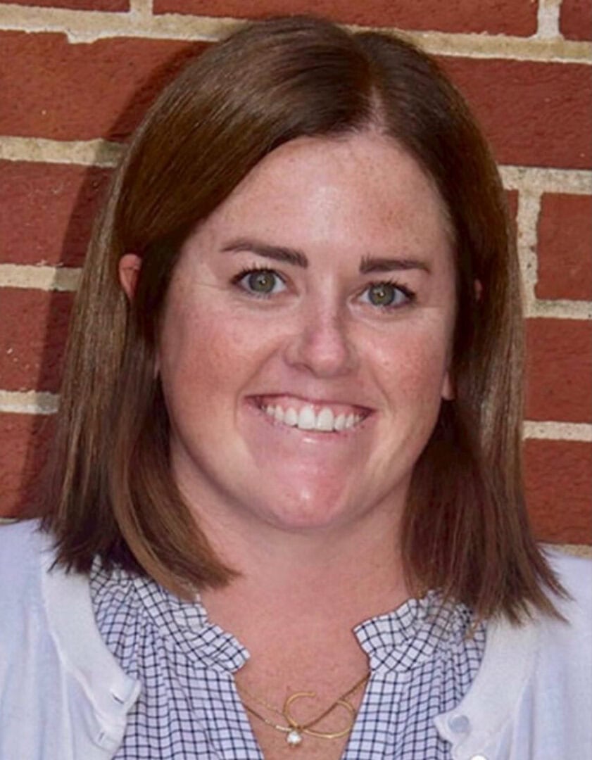 Friendly young woman smiling at Camp One Step outdoor camp event.