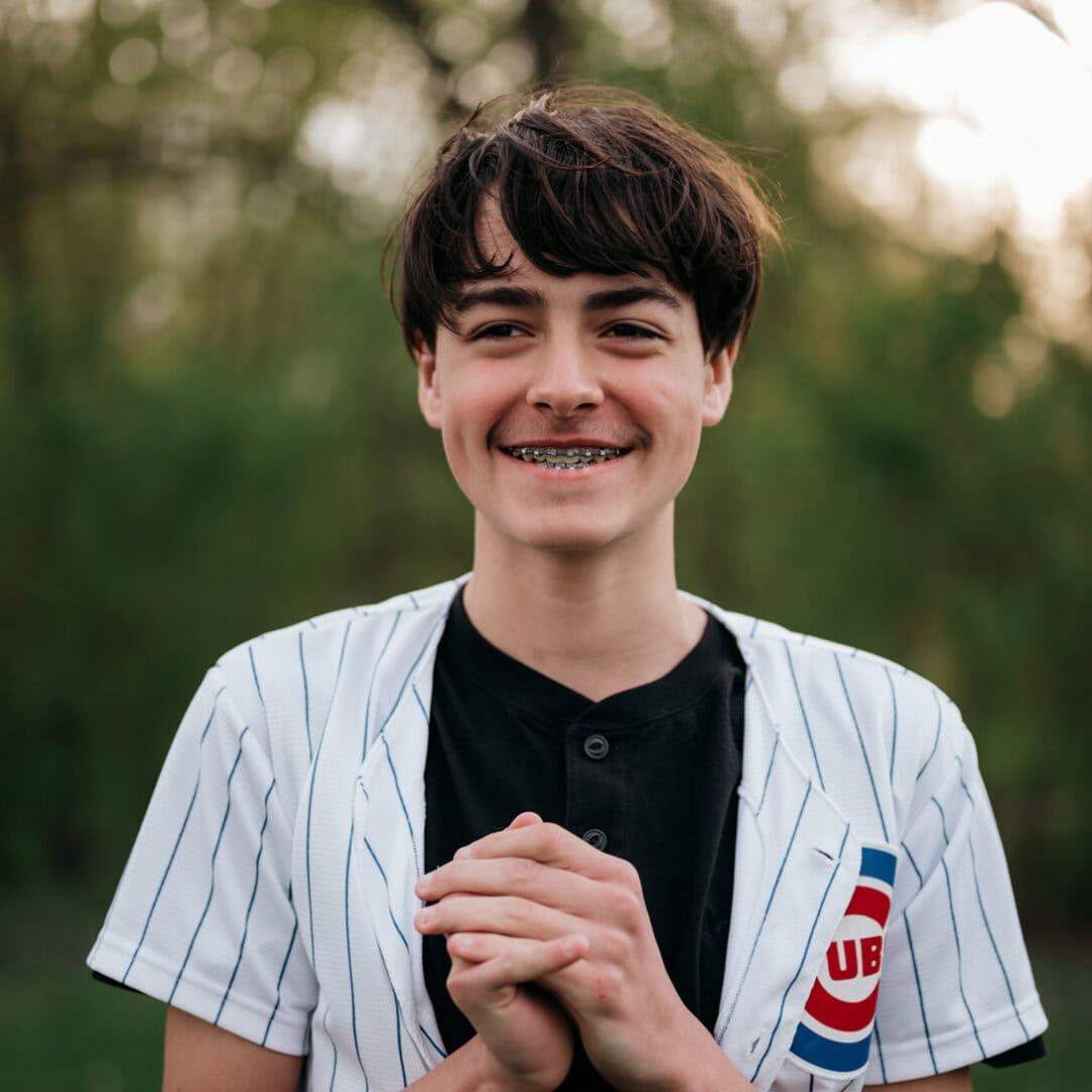 Youth smiling at Camp One Step outdoor camp, enjoying nature and friendship.