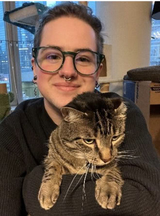 Comfortable woman holding tabby cat at Camp One Step adoption event.