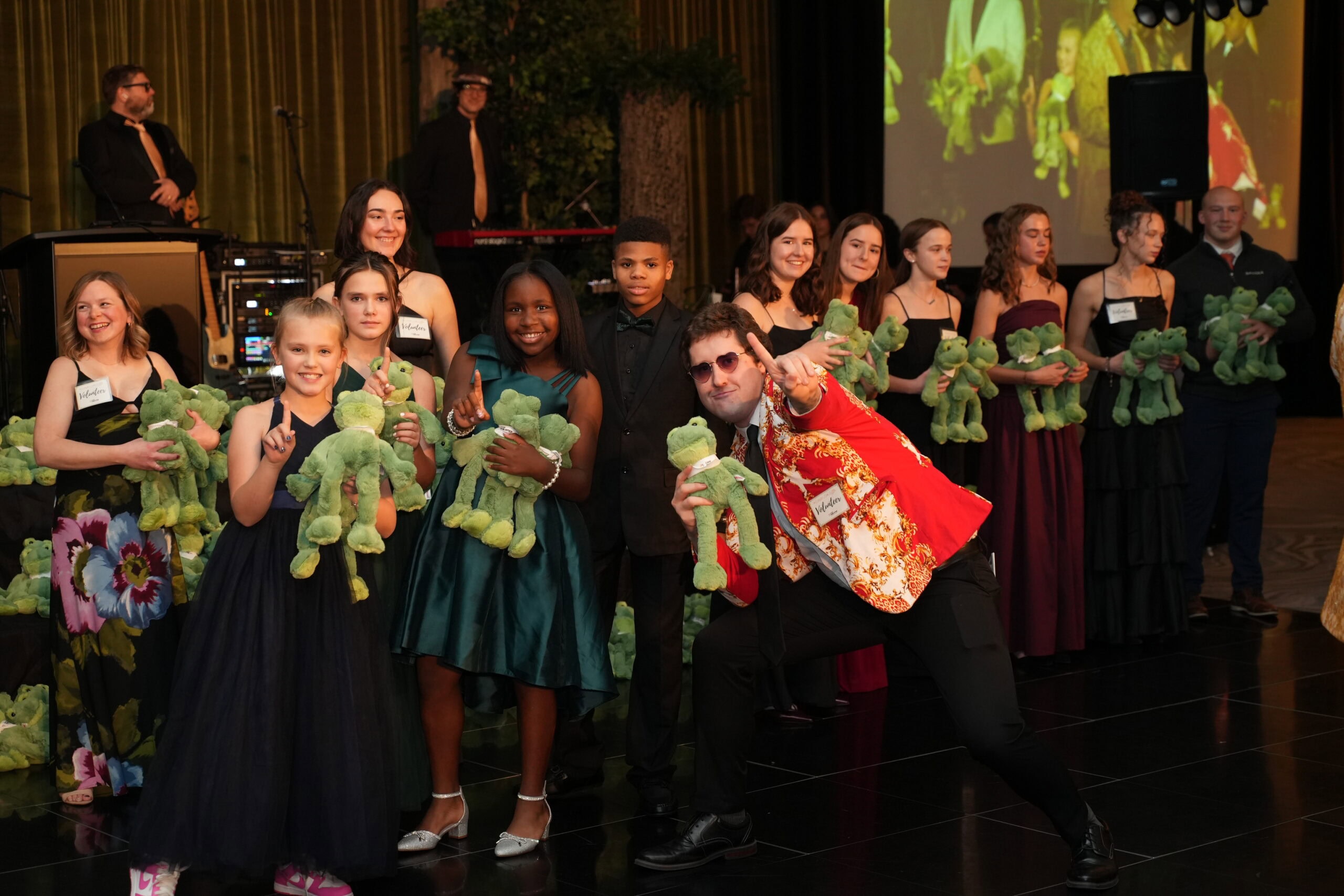 Children holding plush frogs during charity event at Camp One Step.