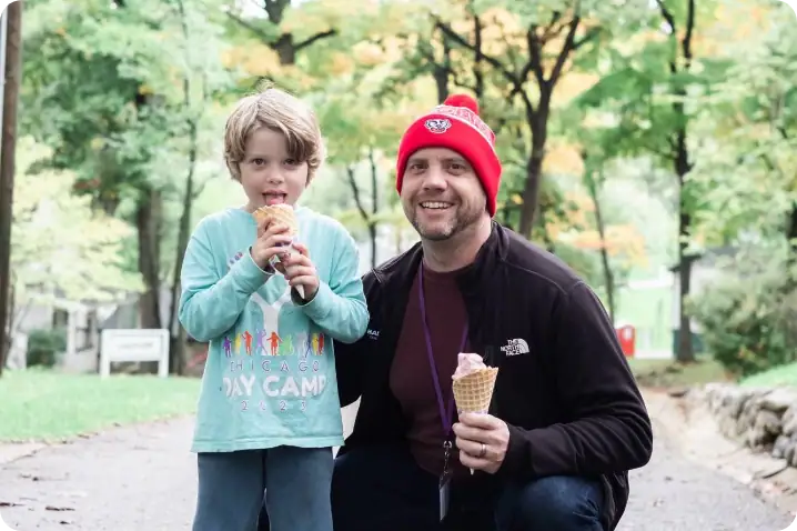Ice cream enjoyed by father and son at Camp One Step outdoor setting.