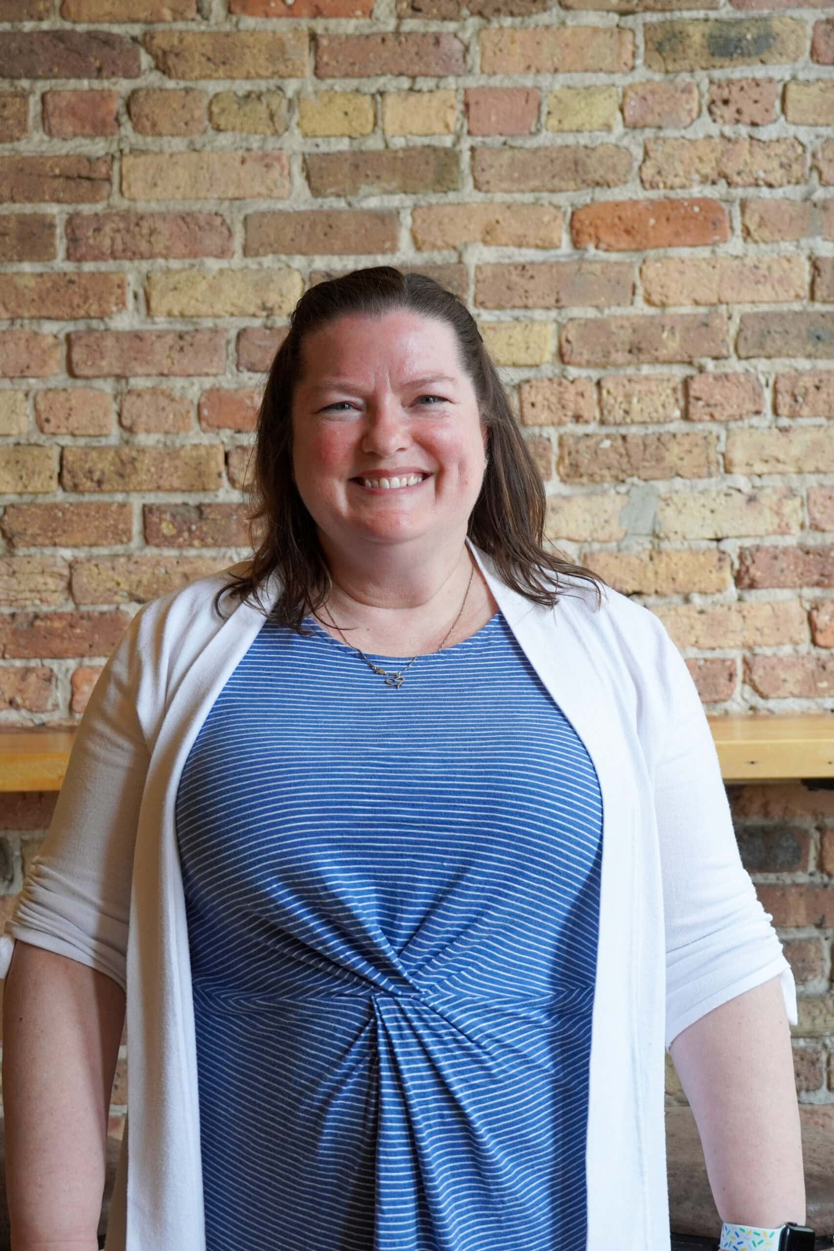 Friendly woman smiling at Camp One Step, inspiring outdoor activities, community support, and personal growth.