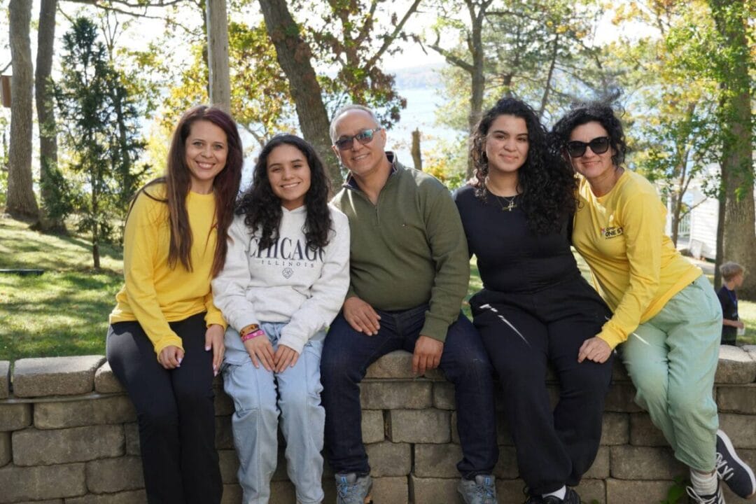 Family enjoying outdoor camp experience at Camp One Step, surrounded by nature and vibrant fall foliage.