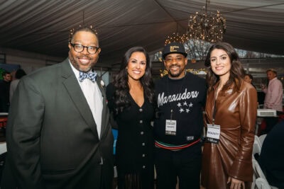 Diverse group of professionals networking at Camp One Step charity event in elegant setting.