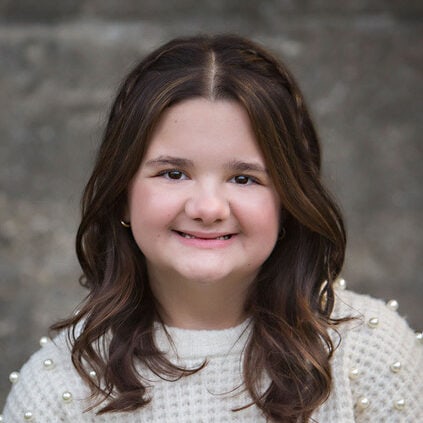 Warm smiling girl at Camp One Step outdoor retreat, empowering children with special needs.