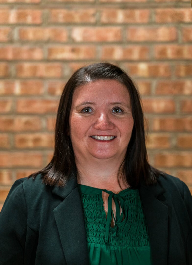 Dedicated staff member at Camp One Step in front of brick wall.