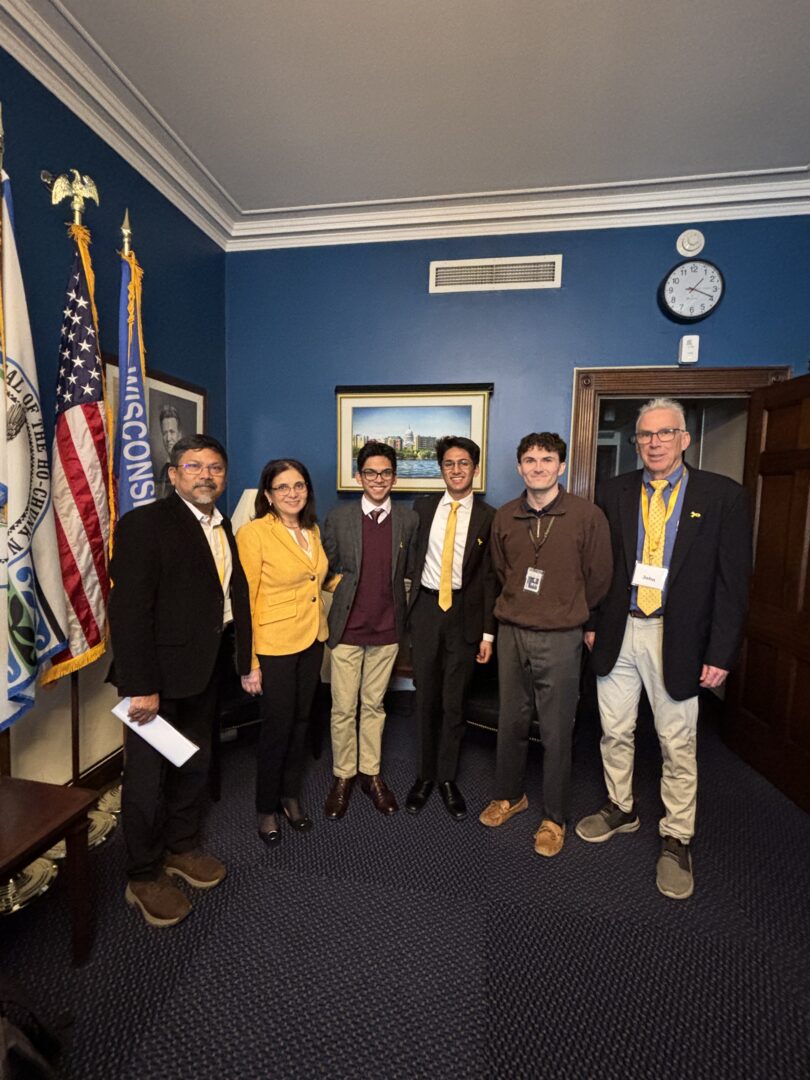 Diverse group of young individuals and adults at Camp One Step event in formal attire.
