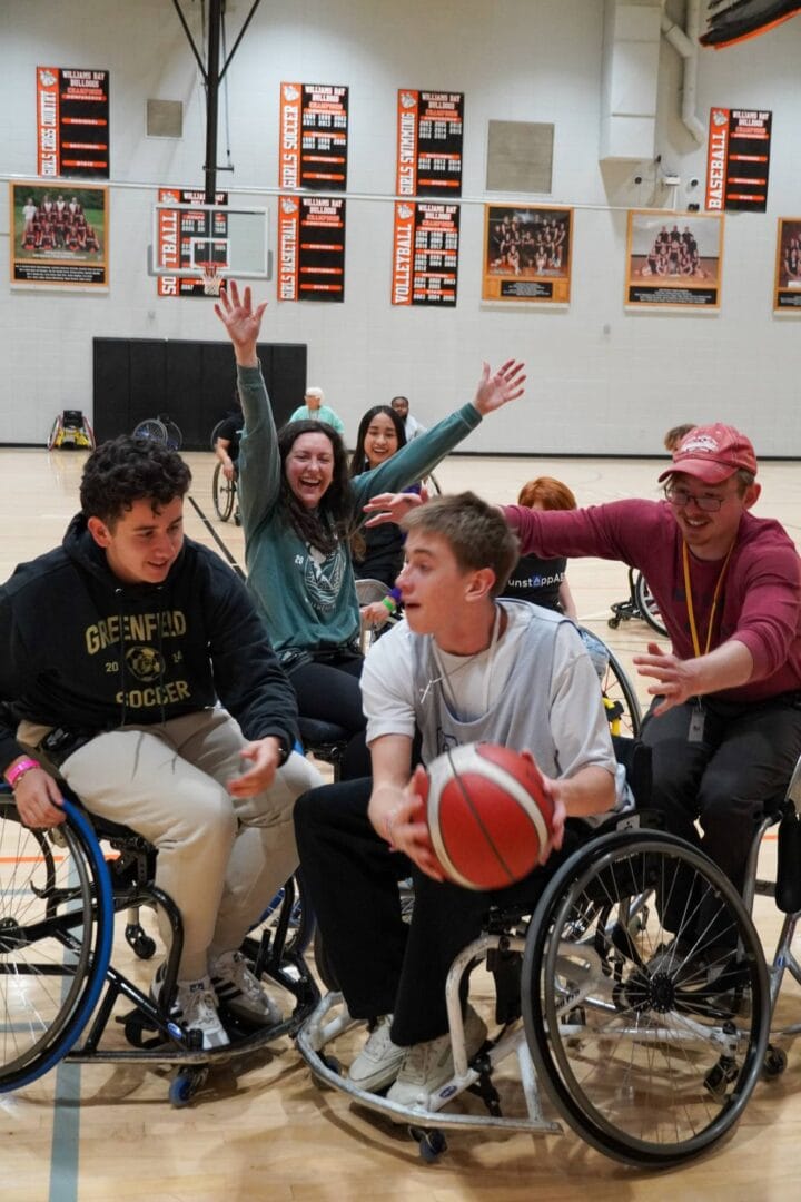 Happy wheelchair basketball players celebrating victory at Camp One Step.