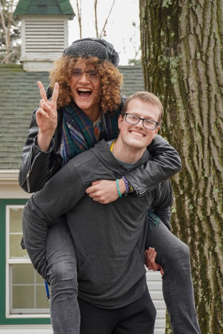 Smiling young couple outdoors, Camp One Step, happiness, friendship, camping, outdoor activities, community outreach, nature, joyful moments.