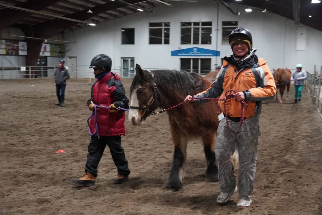 Adventurous horse riding therapy session at Camp One Step indoor arena.