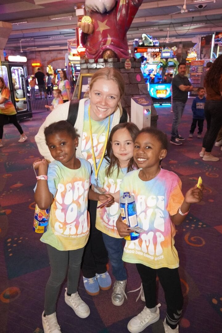 Colorful group enjoying arcade games at Camp One Step, emphasizing fun and family activities.