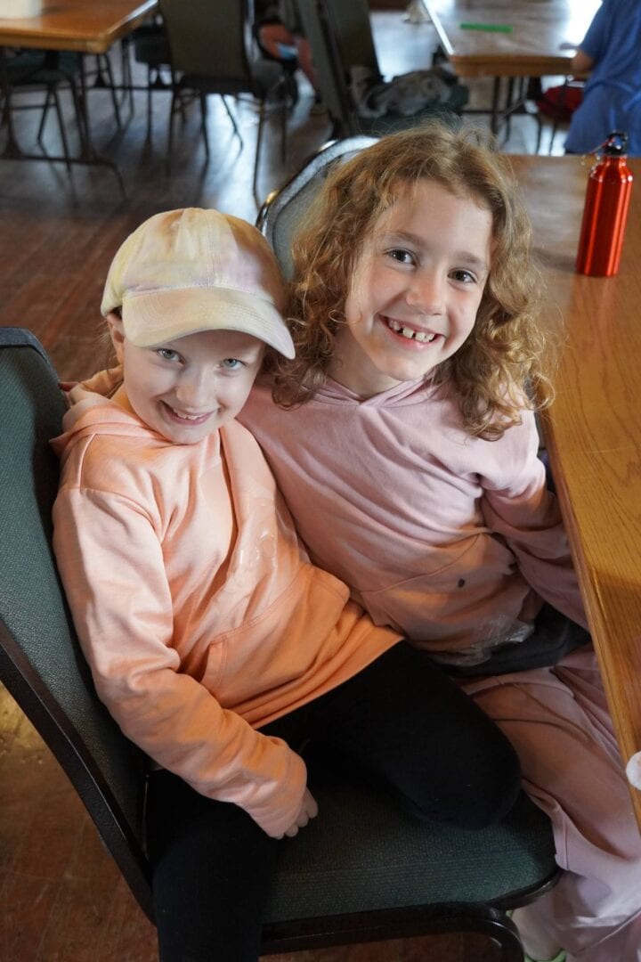 1. Smiling children at Camp One Step indoor activity, fostering friendship and support.