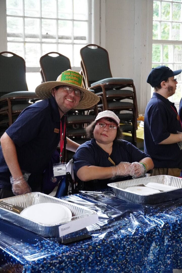 Volunteer staff at Camp One Step preparing and serving food for charity event.