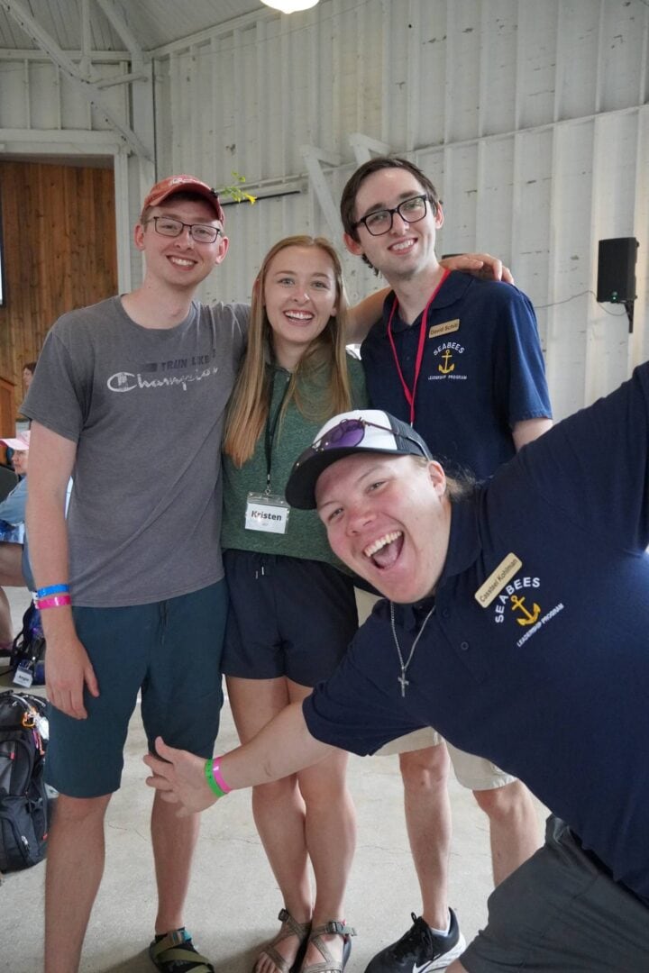 Enthusiastic group smiling at Camp One Step leadership event.