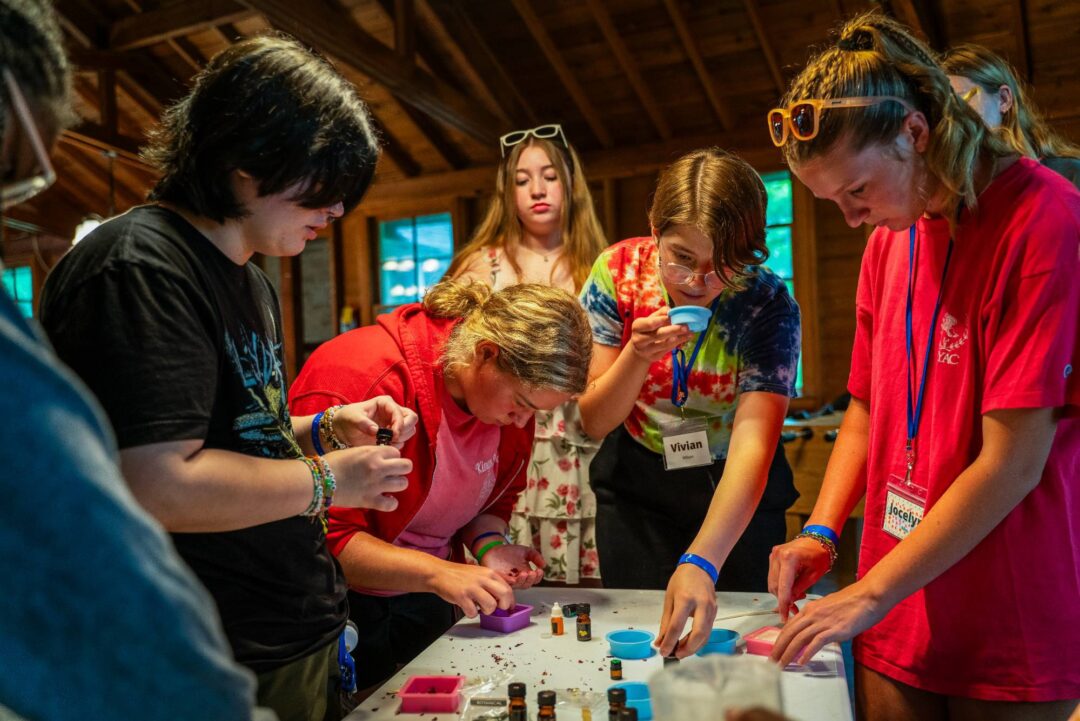 Group of kids doing science experiments indoors at a summer camp.