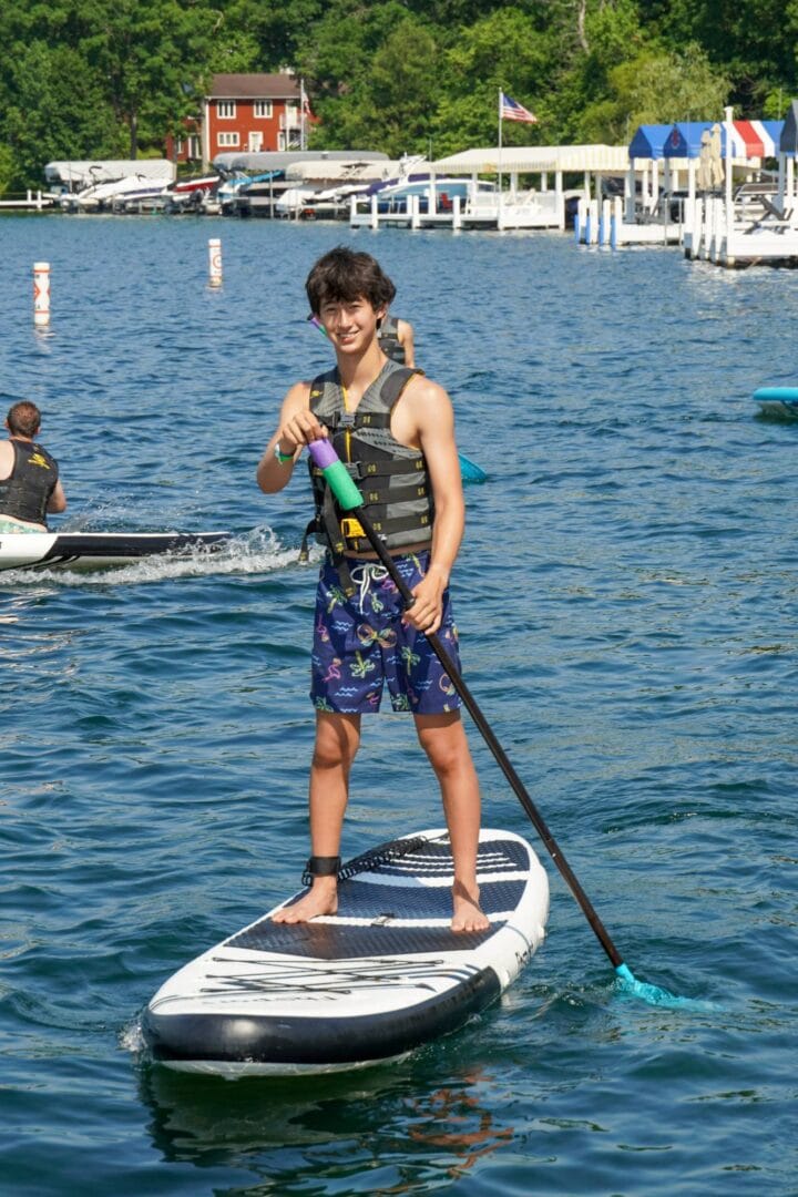 Enjoy fun-filled paddleboarding activities at Camp One Step on beautiful Lake, perfect for summer campers.