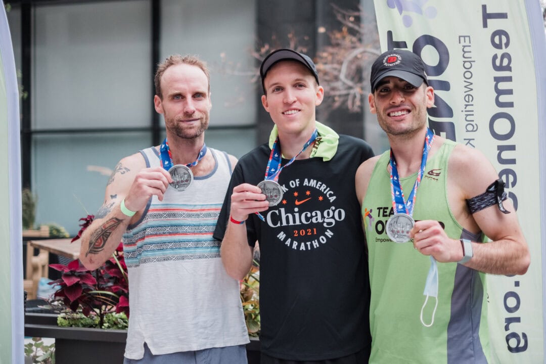 Athletes displaying medals after completing a marathon at Camp One Step.