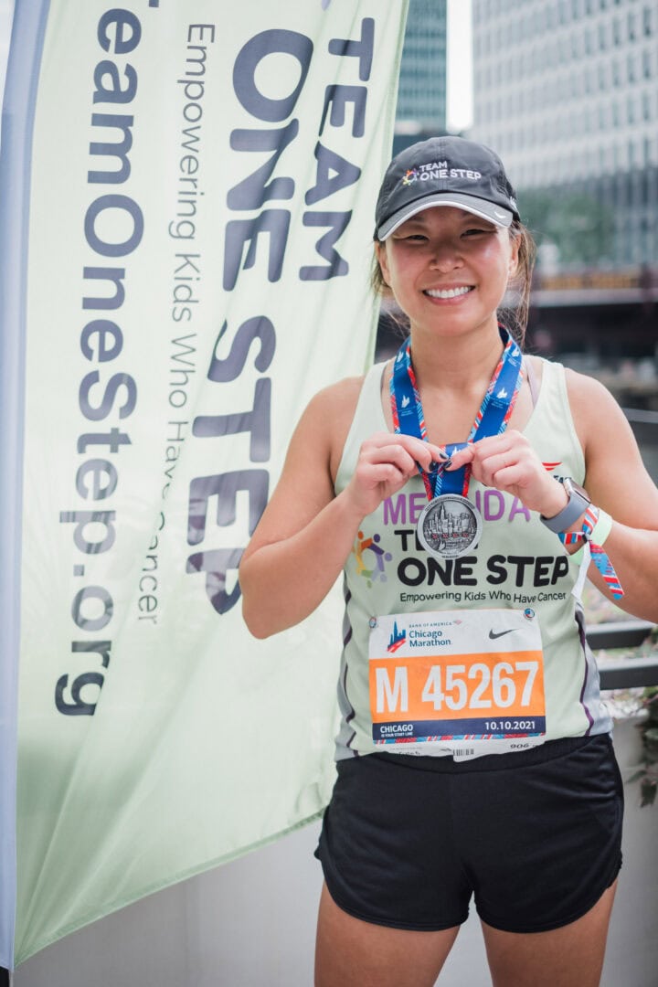 Athlete proudly displays her medal after completing Chicago Marathon supporting kids with cancer.