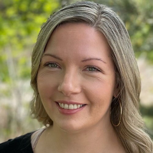 Peaceful woman smiling outdoors at Camp One Step, outdoor therapy, mental health support, ​​nature healing.