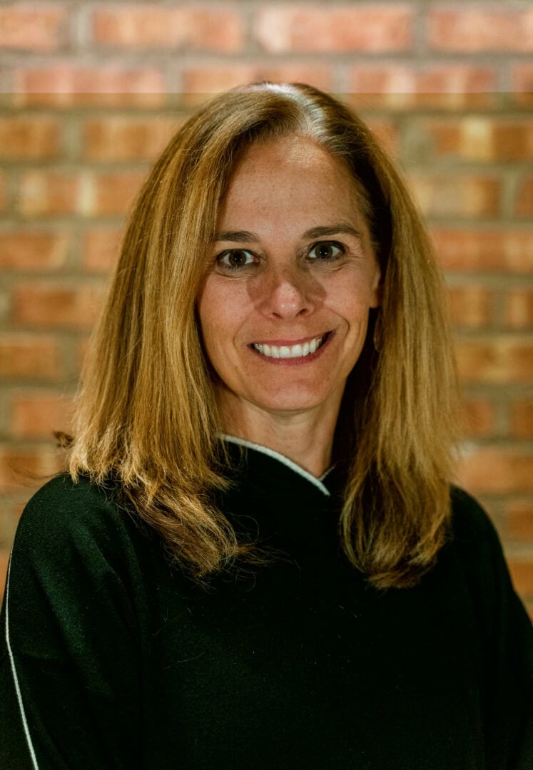 Portrait of smiling woman at camp, showcasing welcoming environment and supportive community.