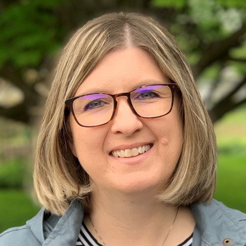 1. Woman smiling outdoors at Camp One Step, peace, support, and community in nature.
