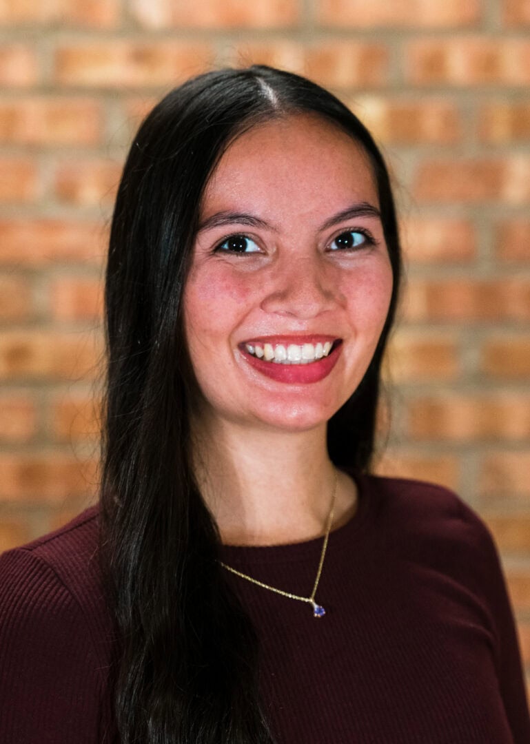 Smiling woman with dark hair at Camp One Step, outdoor retreat, joyful, happy, positive energy.