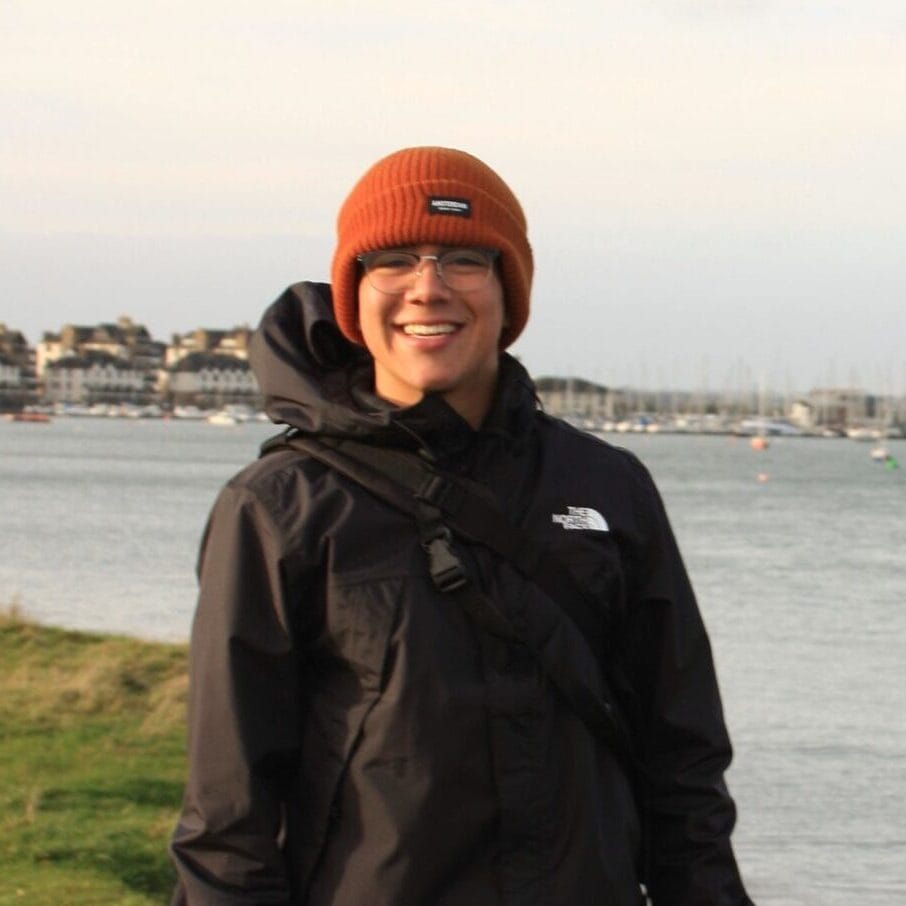 Warm outdoor adventure at Camp One Step by the waterfront with smiling camper in winter gear.