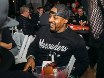 Smiling man at Camp One Step charity event, engaging with guests and enjoying social activities.