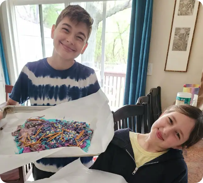 1. Smiling boy holding decorated cake at Camp One Step.