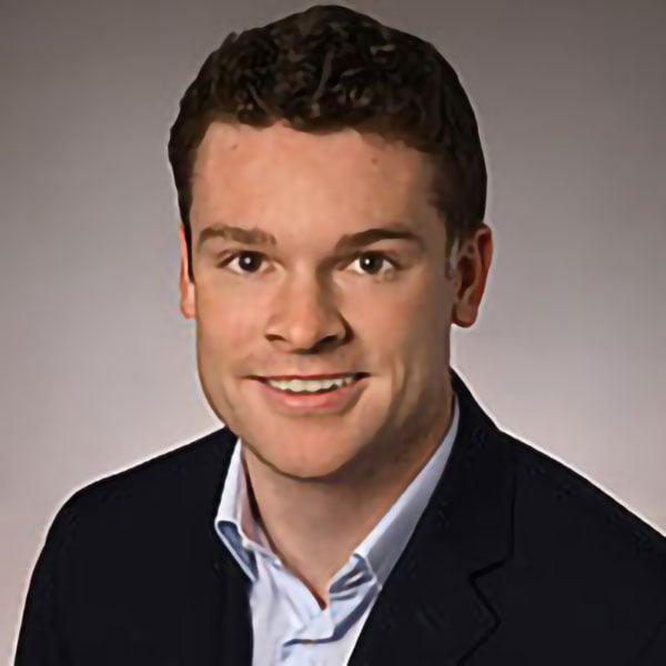 Bright smiling young man in professional attire for Camp One Step campaign.