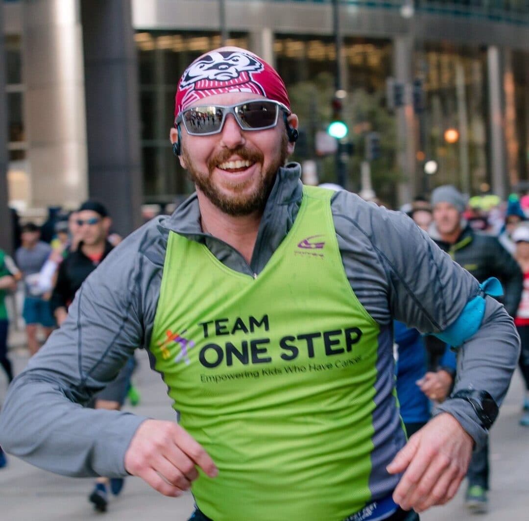 Active runner wearing Team One Step sports vest at charity marathon event.