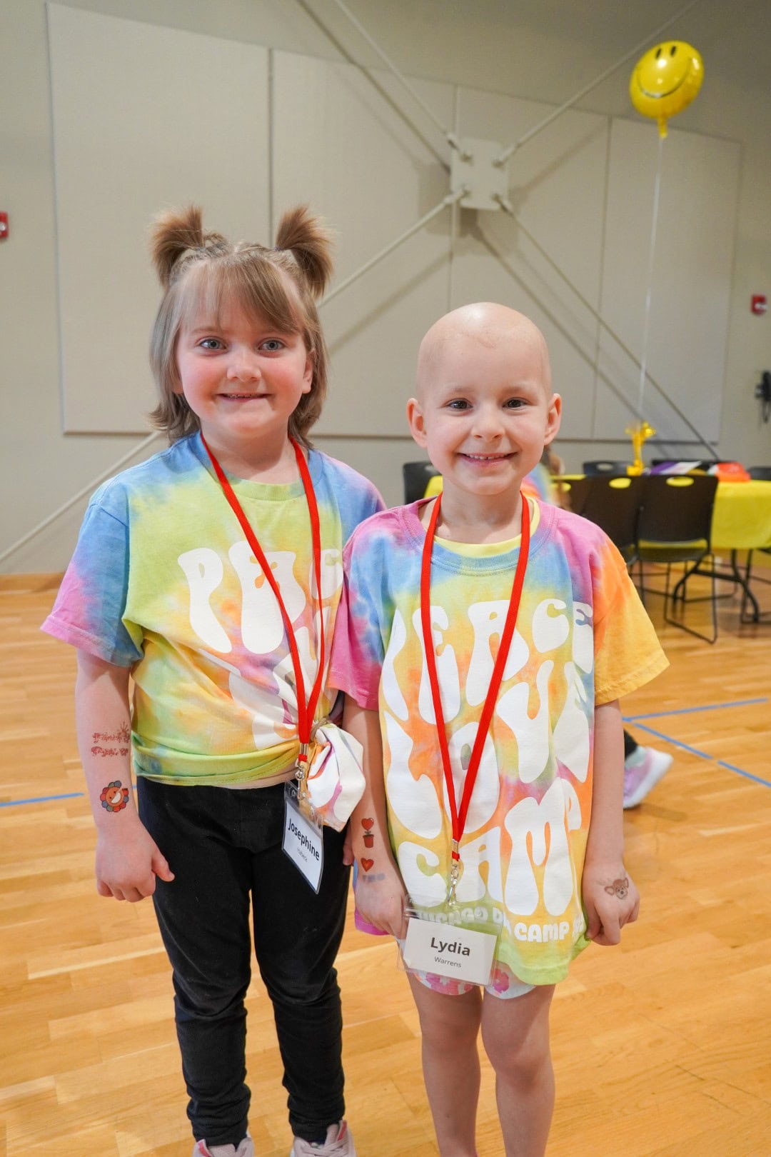 Happy children at Camp One Step smiling for a photo in colorful tie-dye shirts.