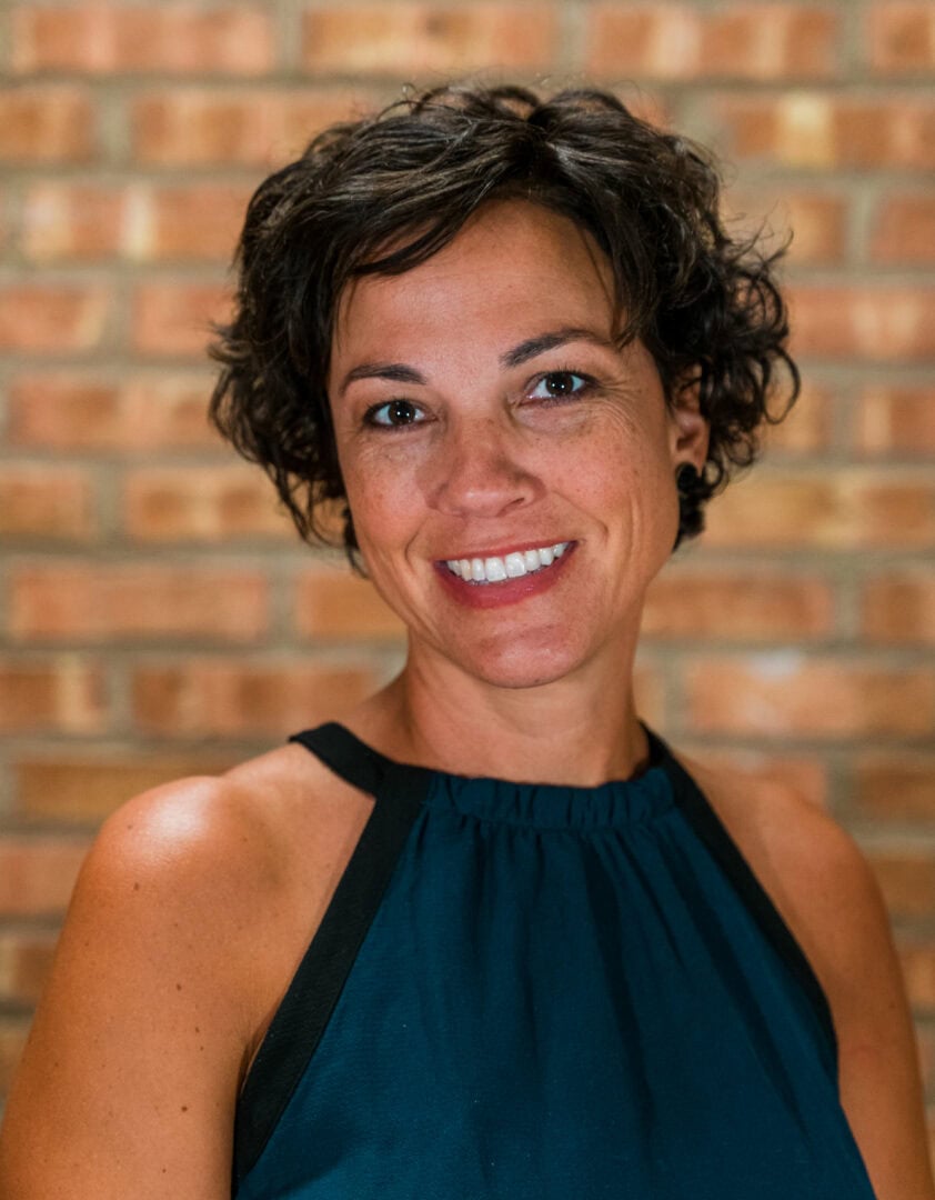 Happy woman smiling at Camp One Step youth camp.