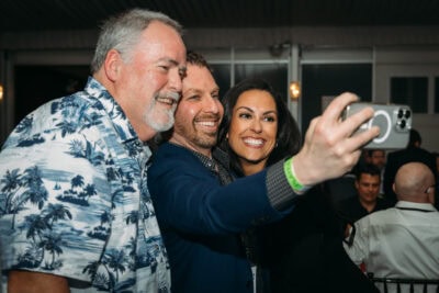 Joyful group taking selfies at Camp One Step fundraising event, showcasing community engagement and support.