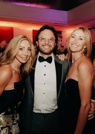 Elegant group of people at Camp One Step fundraising event with smiles and formal attire.