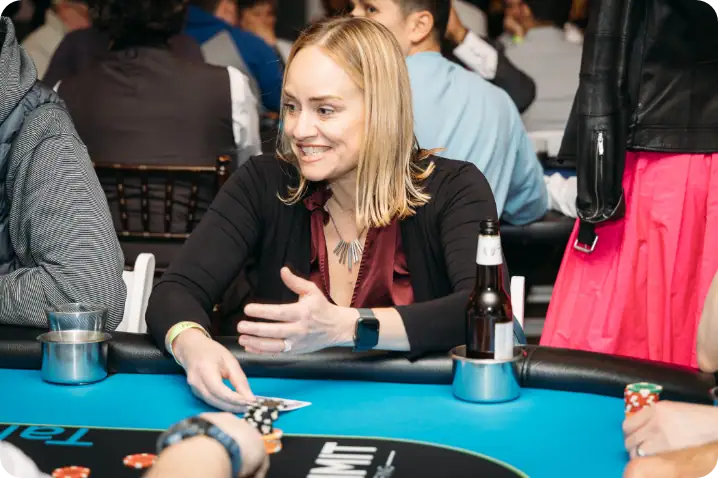 Cheerful woman playing poker at Camp One Step charity casino night event.