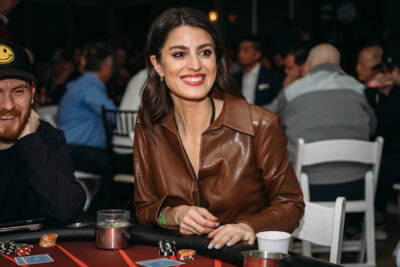 Smiling woman enjoying a game night at Camp One Step charity event.