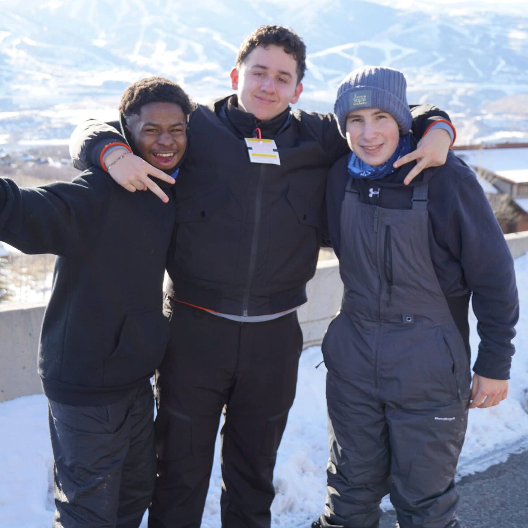 Ages of group of three friends enjoying winter at Camp One Step in snowy mountains, outdoors.