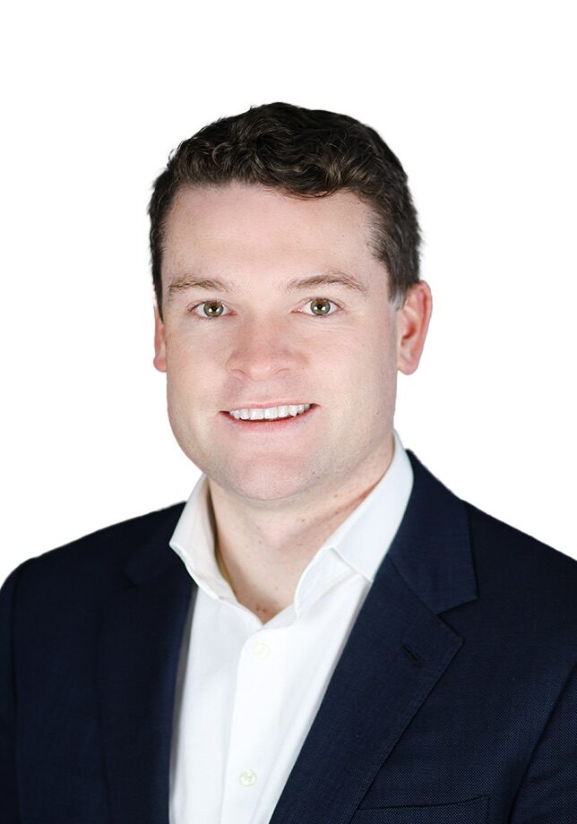 Smiling man in navy suit against white background