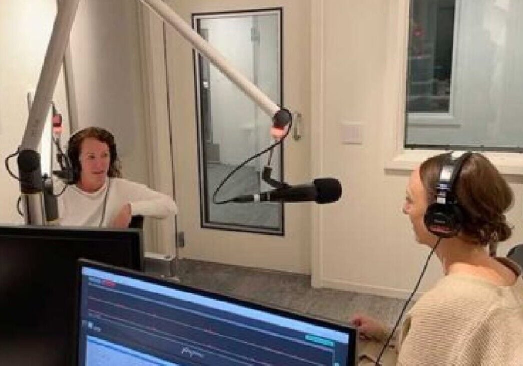 Young woman recording podcast at Camp One Step radio studio, emphasizing mental health support.