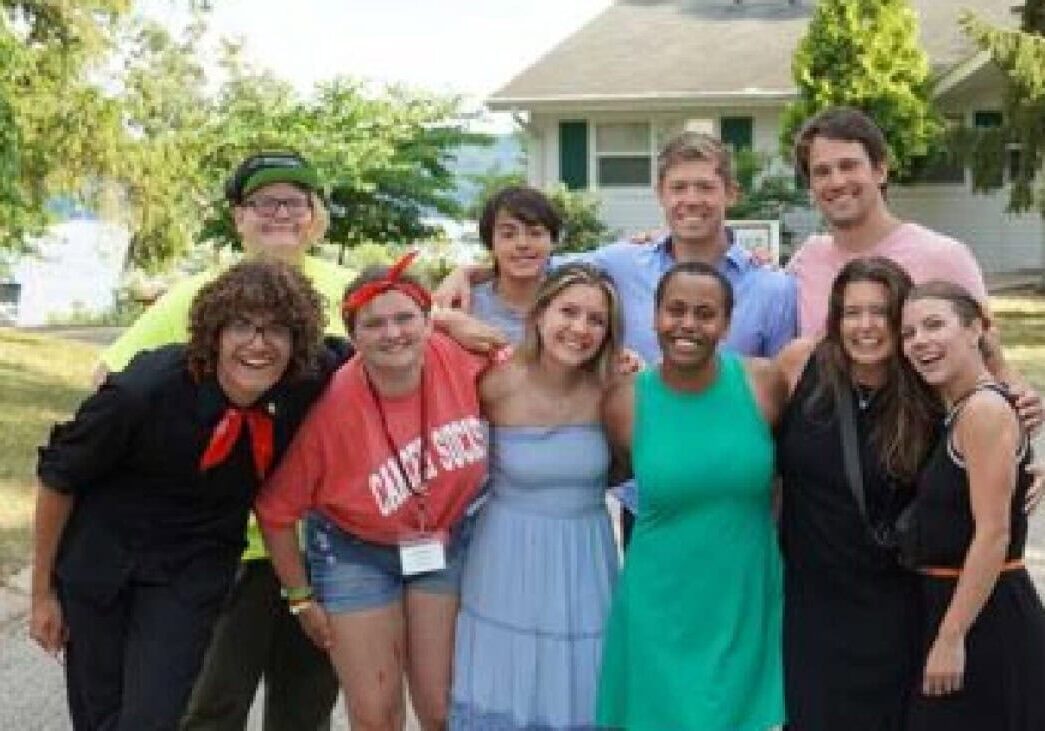 Vibrant group of camp counselors and campers at Camp One Step summer camp in a neighborhood setting.